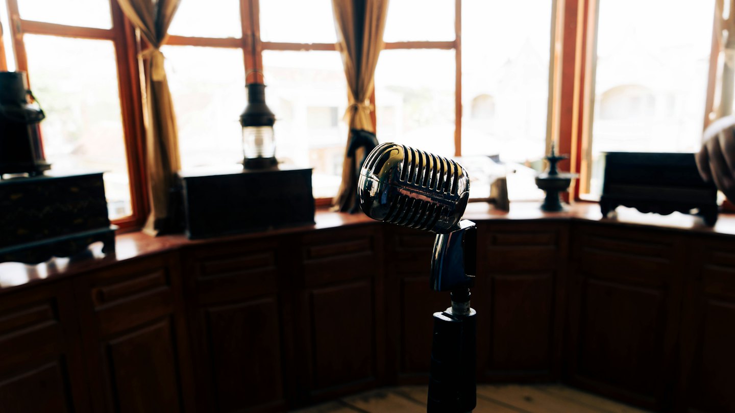 Silver vintage microphone on a stand indoors.