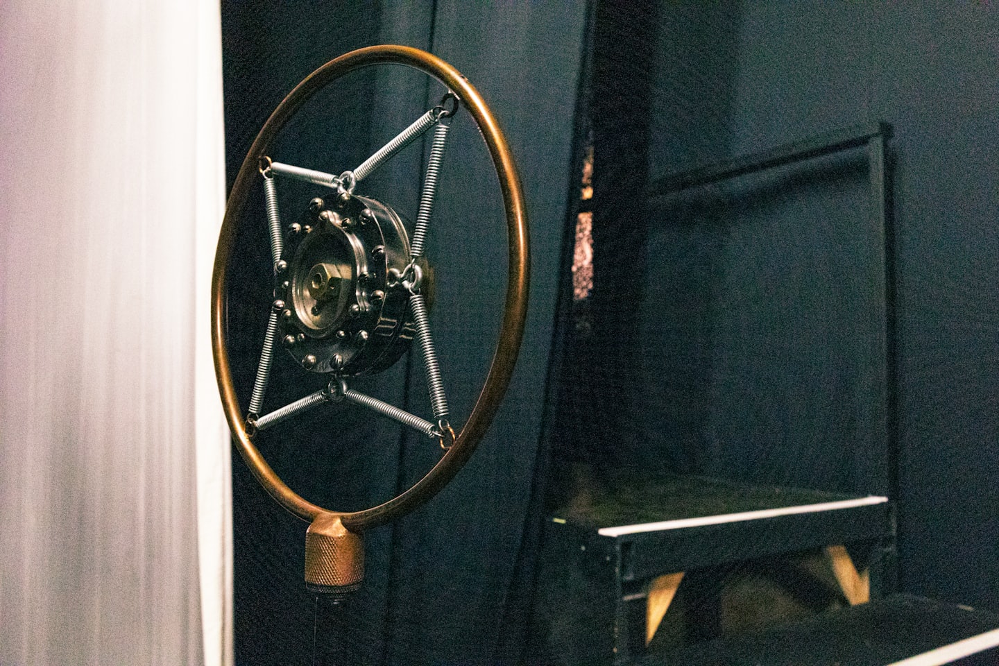 Vintage brass microphone suspended in a recording studio.