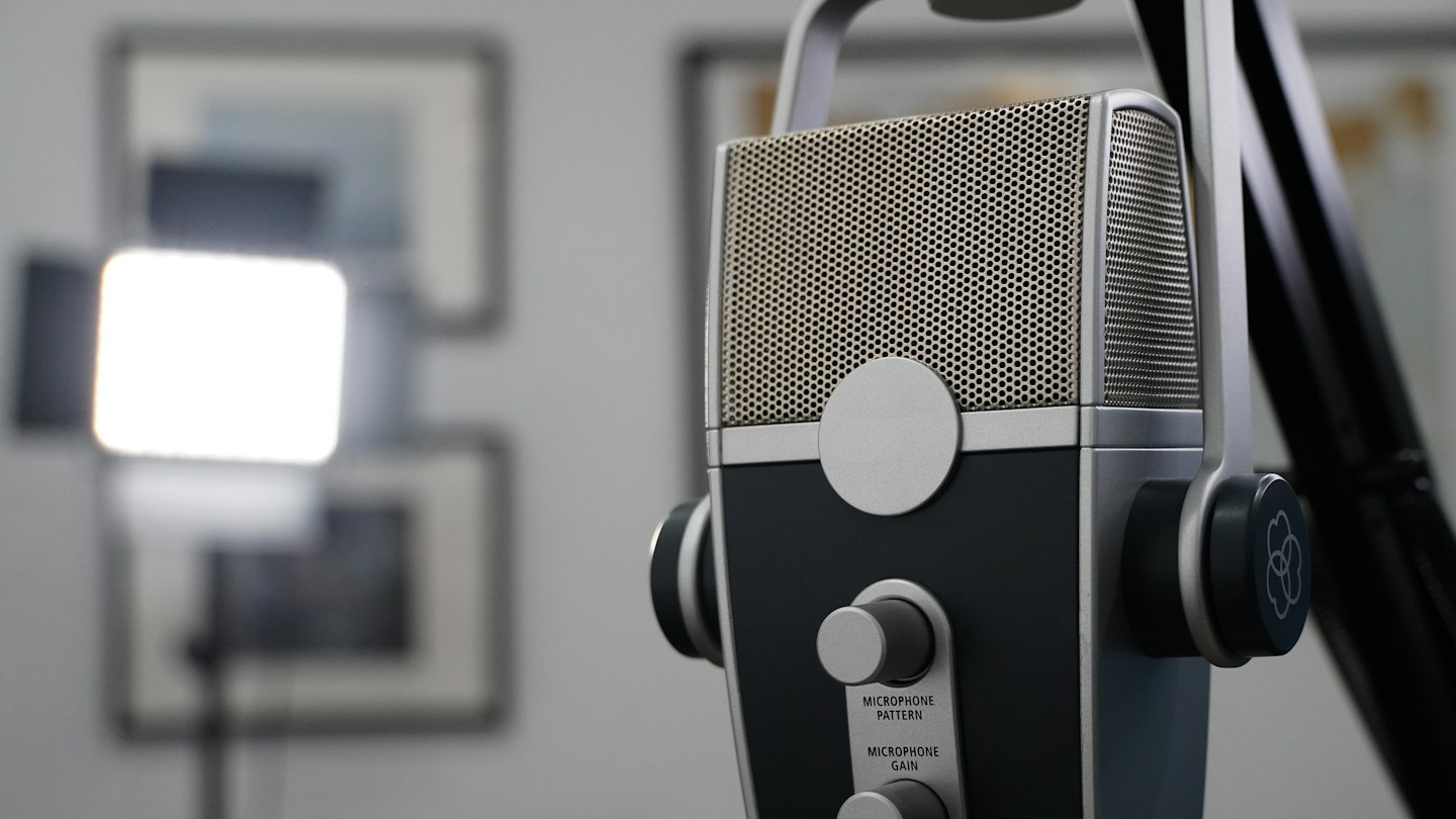 A professional studio microphone mounted on an adjustable arm.